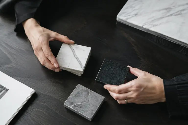Échantillons de marbre, granit et quartz comparés sur une table